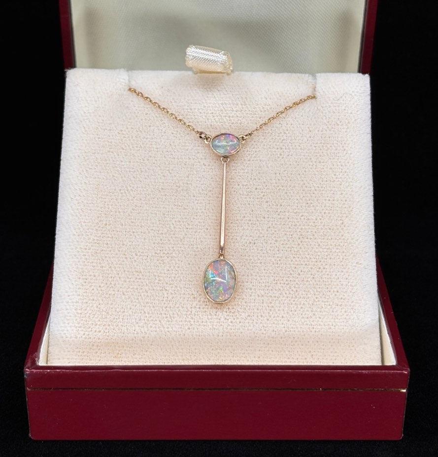 antique opal pendant necklace displayed in a luxurious box, highlighting two exquisite Lightning Ridge opals in a fine, delicate gold setting.