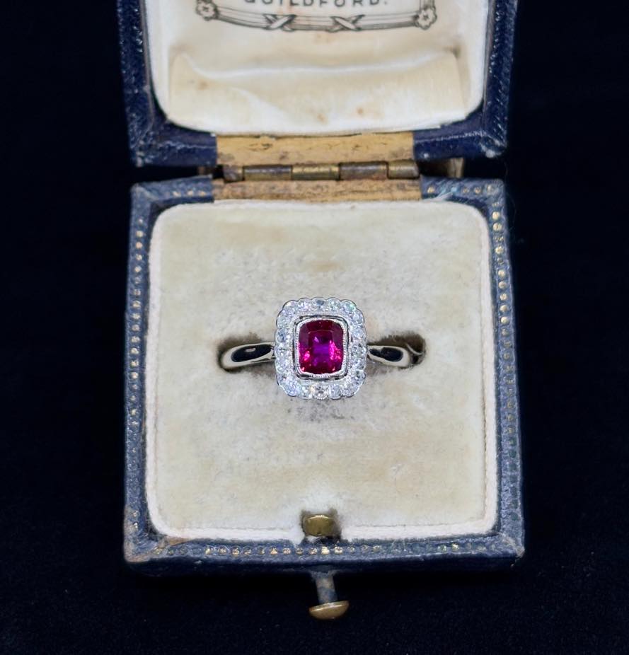 Unique handcrafted ruby and diamond cushion cluster ring, circa 1920s, featuring a saw-pierced gallery and elegant design.