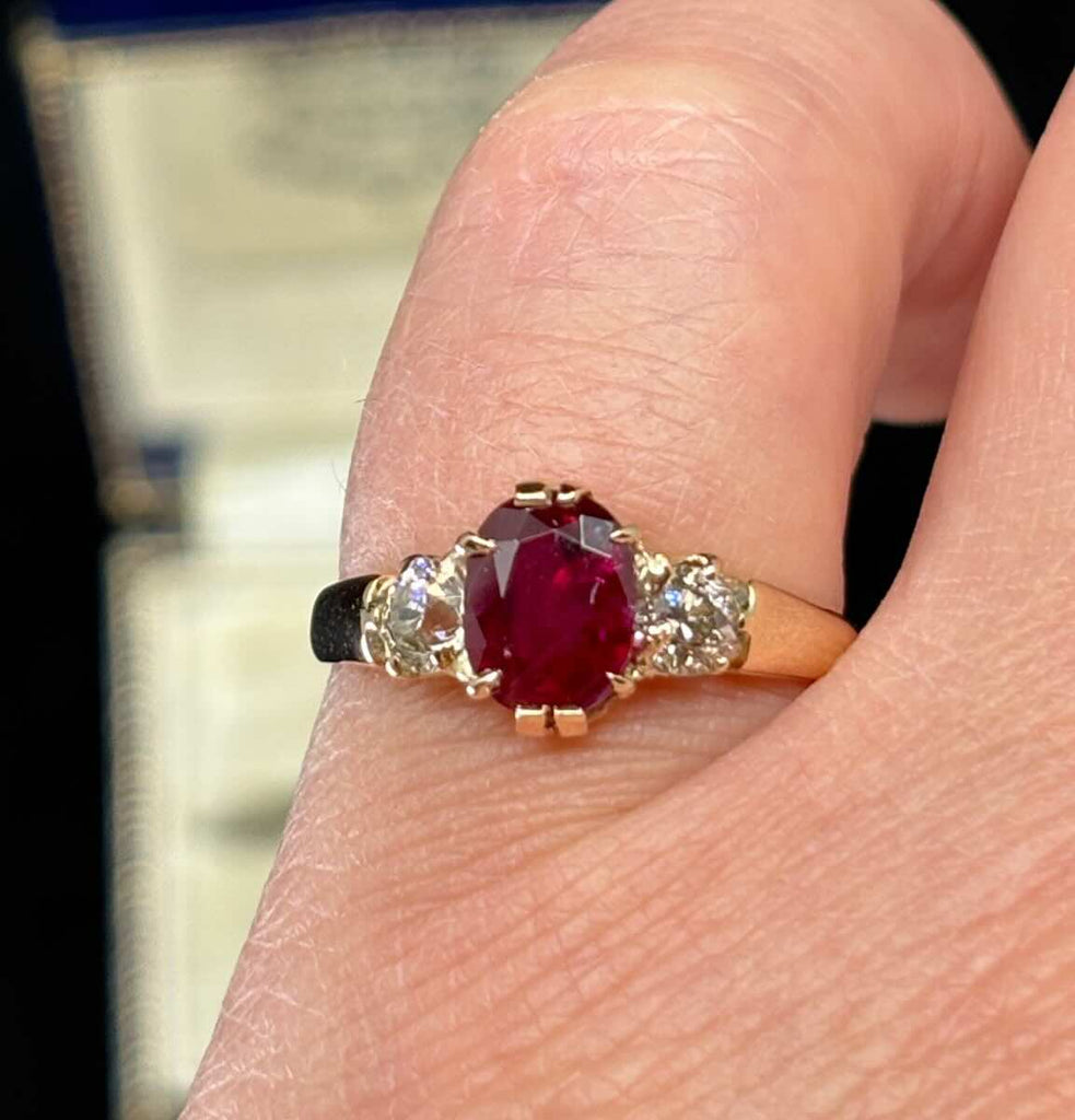 Antique Edwardian 1905 three‑stone ring with 2.53ct oval ruby and two old‑European cut diamonds (0.46ct) in 9ct yellow gold — claw set, vintage engagement ring.