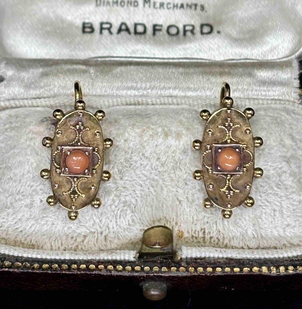 Antique Etruscan revival coral earrings showing cannetille scrollwork and coral cabochons