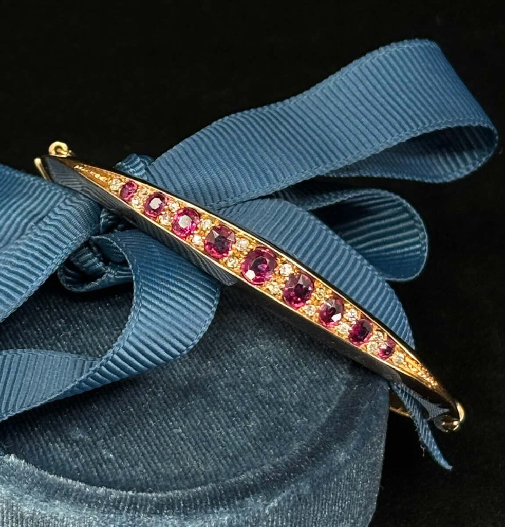 Antique Victorian ruby bangle featuring 1.65ct total of graduated oval natural rubies and bead‑set old‑cut diamonds