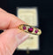 Antique Victorian ruby and diamond half hoop ring featuring cushion cut ruby and two round rubies set in 18ct yellow gold.