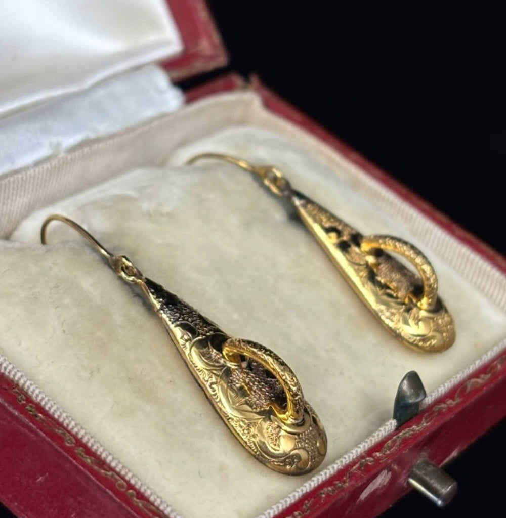 Antique Victorian yellow gold drop earrings shown at an angle in a jewellery box
