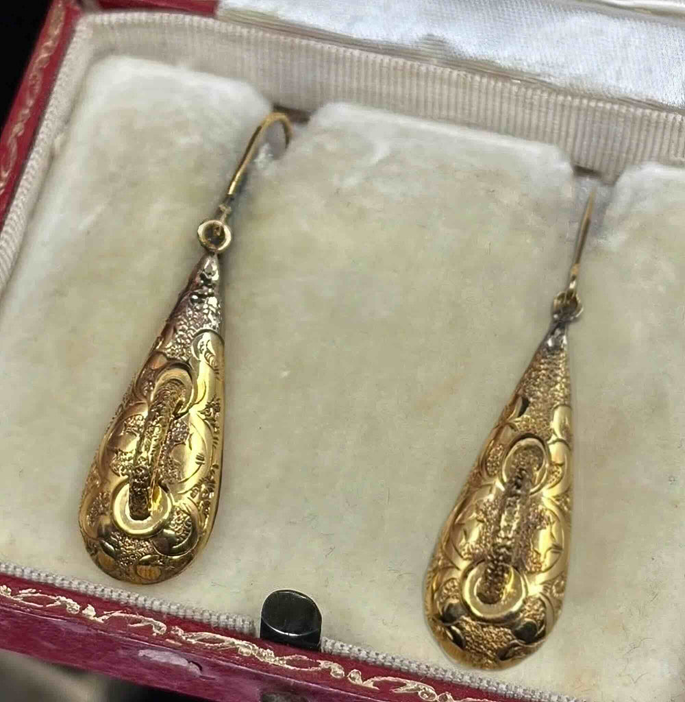 Antique Victorian gold earrings showing hand-engraved scrolling foliage and swivel ring detail