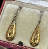 Antique Victorian gold earrings showing hand-engraved scrolling foliage and swivel ring detail