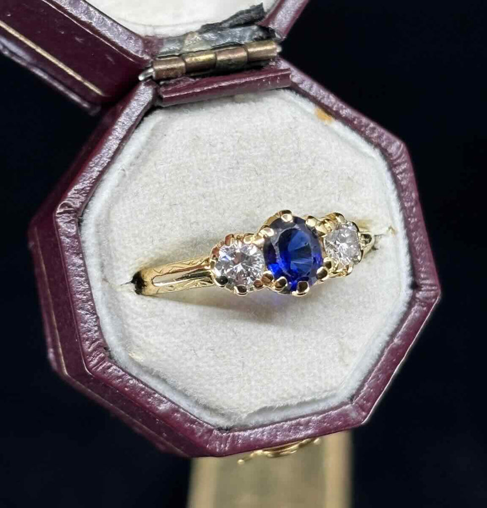 Antique style claw‑set sapphire and diamond ring from the 1950s, featuring a deep blue 0.50ct sapphire and two G VS diamonds in an 18ct yellow gold setting.
