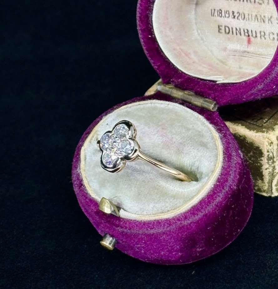 A medieval-inspired ring with a quatrefoil design and diamonds, presented in a luxurious vintage box.