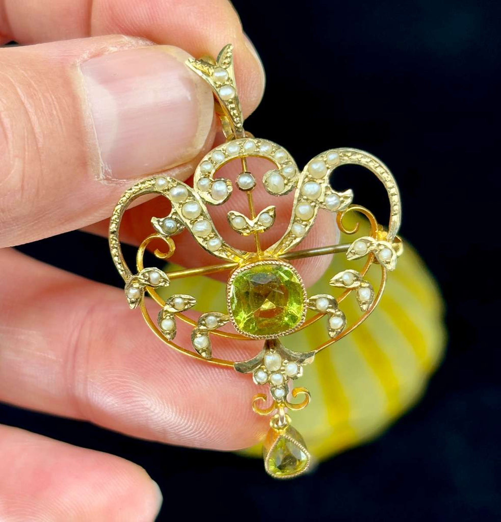 Close-up of ornate Art Nouveau gold scrollwork with natural pearls on antique garnet brooch.