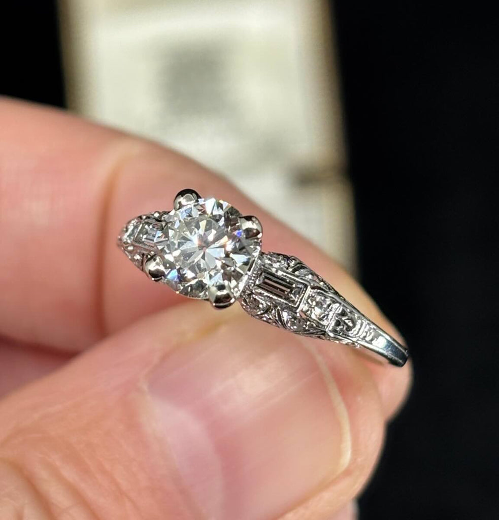 Art Deco platinum ring featuring a 1.25ct centre diamond accompanied by two baguette diamonds and pavé accents.