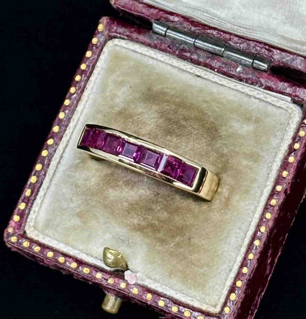 channel set ruby band featured in an antique ring box