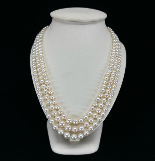 Classic three-strand Akoya pearl necklace with cream rose pearls and diamond clasp.