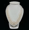 Classic three-strand Akoya pearl necklace with cream rose pearls and diamond clasp.