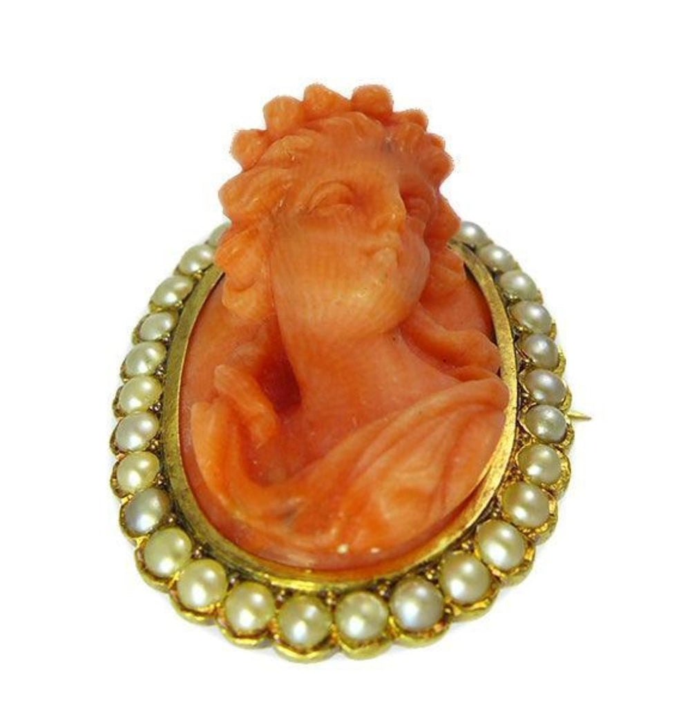Closeup detail of hand‑carved coral maiden cameo surrounded by thirty‑one natural pearls set in 15ct yellow gold.