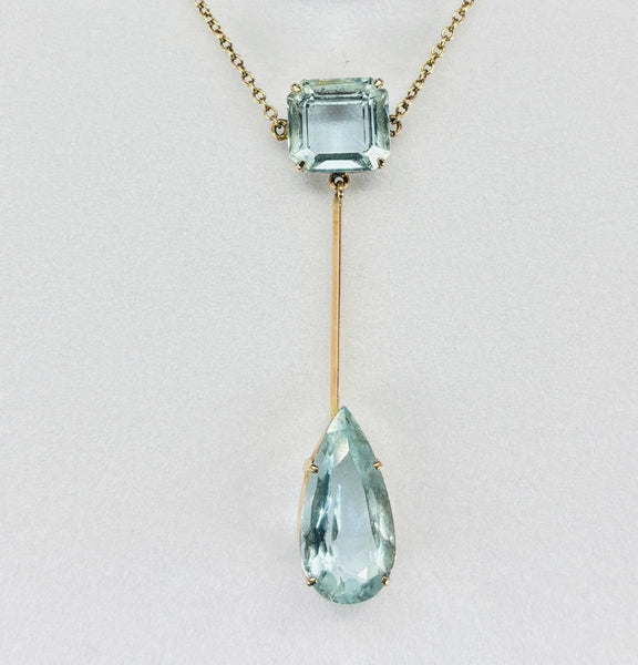 Close up of Edwardian aquamarine pendant showing emerald cut and pear cut aquamarines set in 9ct yellow gold