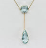 Close up of Edwardian aquamarine pendant showing emerald cut and pear cut aquamarines set in 9ct yellow gold