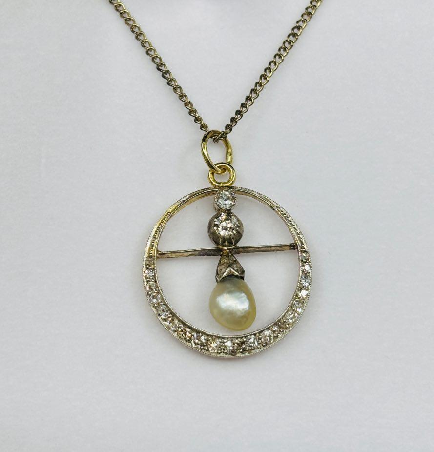 Antique Edwardian natural pearl and diamond pendant featuring a 7.5mm pearl and 29 dazzling diamonds, set in platinum and yellow gold.