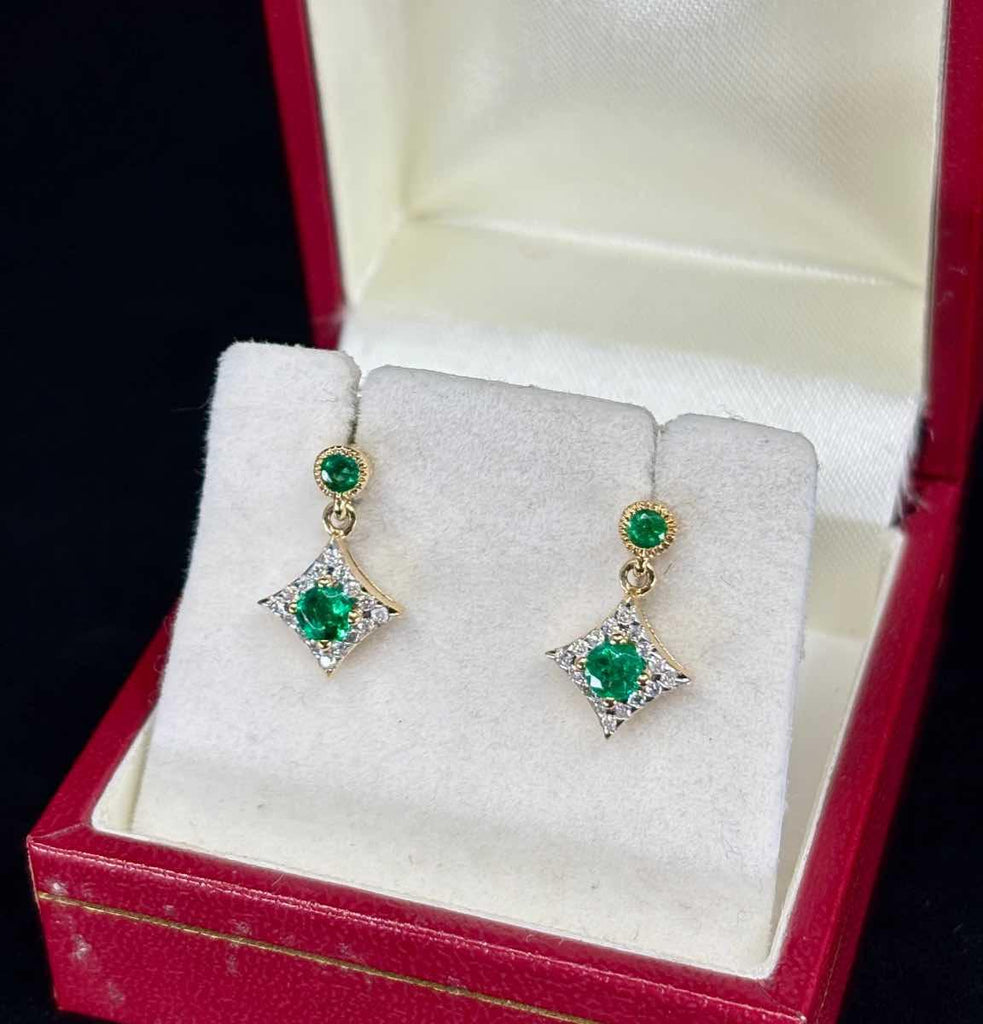 Elegant drop earrings featuring emeralds and diamonds.