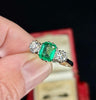 Emerald‑cut 1.15ct untreated Colombian emerald in antique 1930s three‑stone platinum setting.
