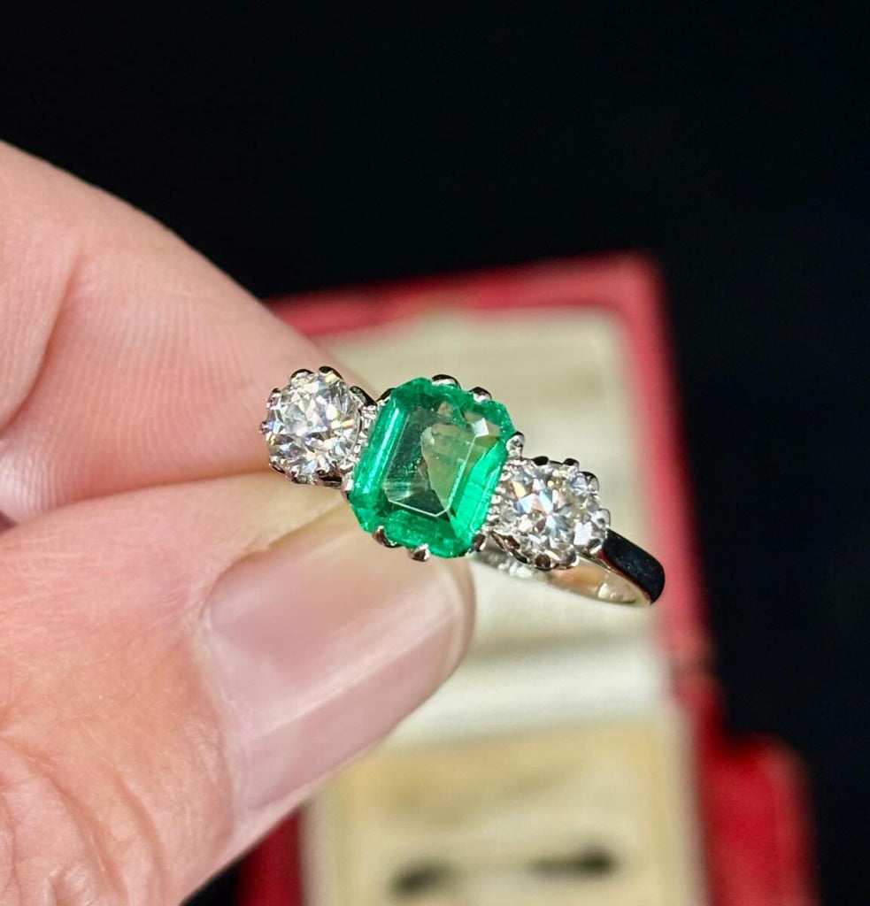 Emerald‑cut 1.15ct untreated Colombian emerald in antique 1930s three‑stone platinum setting.