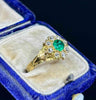 Close-up of fine green emerald and diamond cluster in Victorian gold ring.