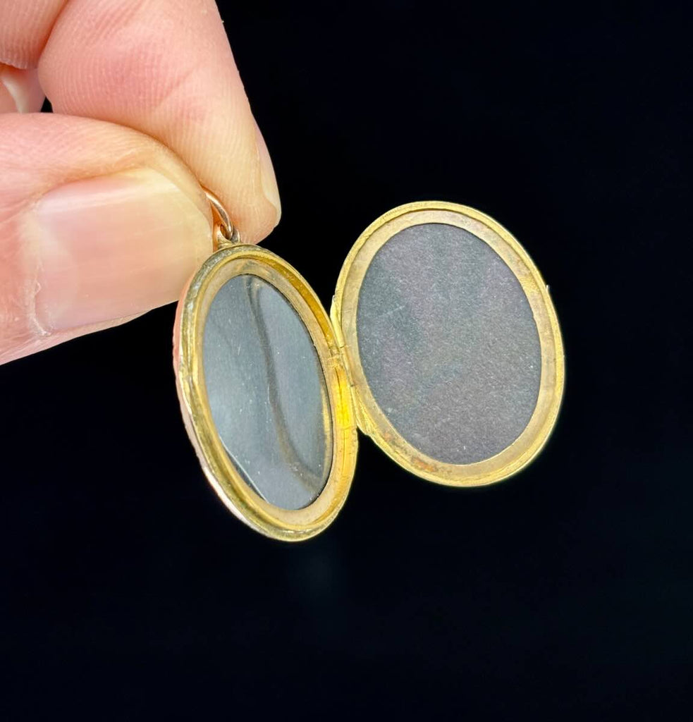 Gold locket from the Victorian era featuring a symbolic bow motif, made in 9ct yellow gold.