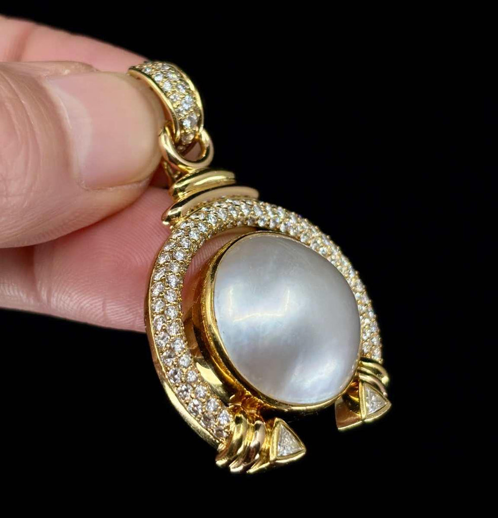 Detailed view of diamonds and Mabé pearl on an elegant pendant with scrollwork design reverse.
