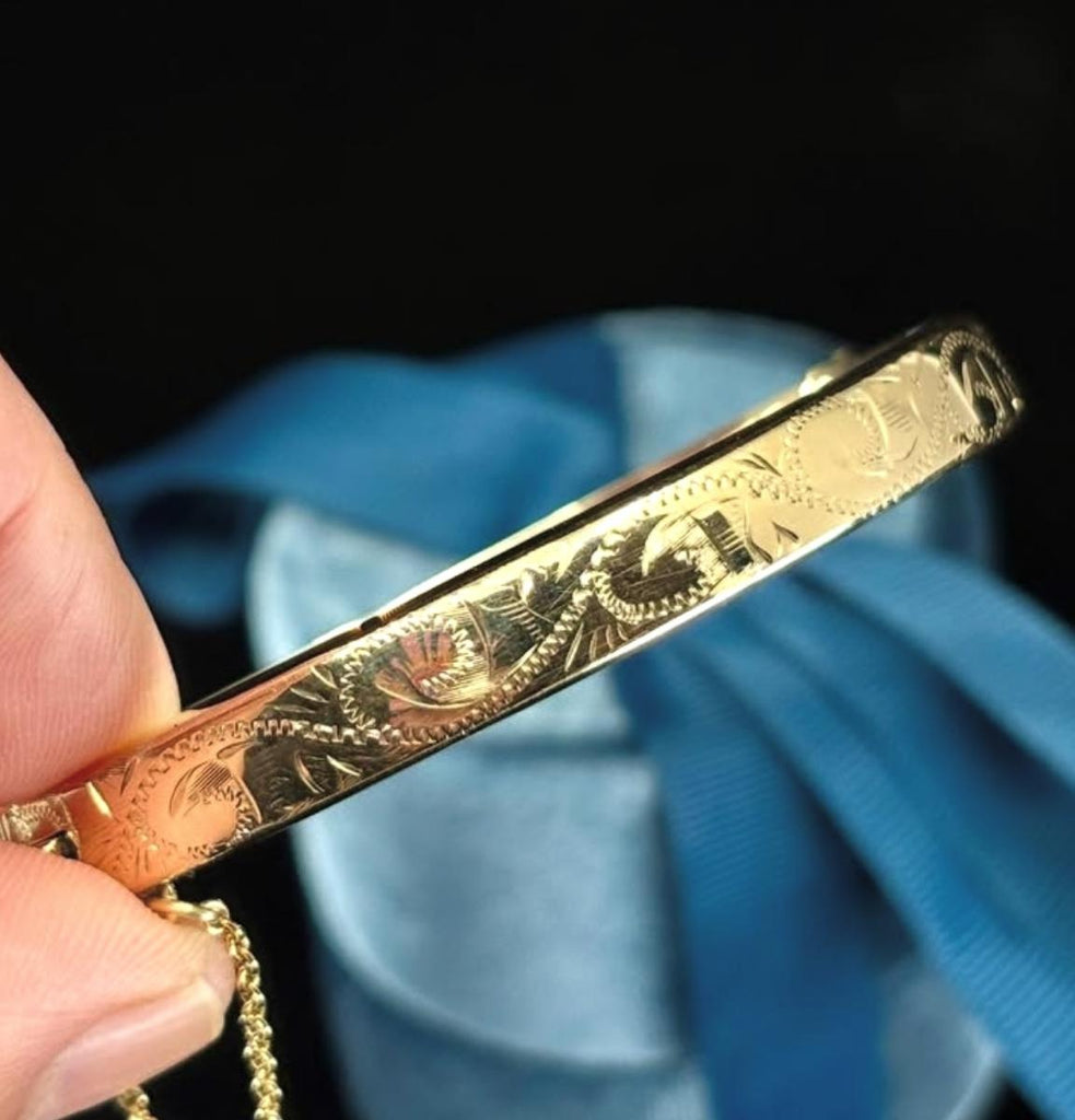 Detail of contemporary 9ct yellow gold hand-engraved hinged bangle scrollwork.