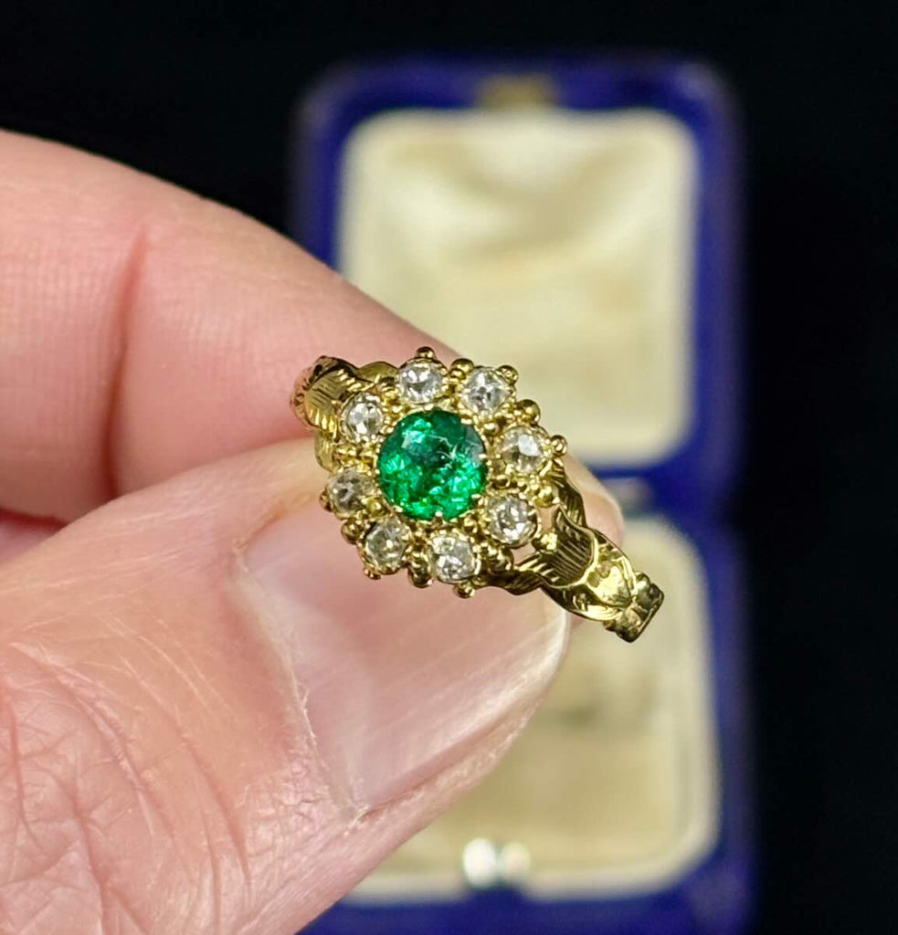 Handmade Victorian ring featuring a fine green emerald surrounded by diamonds.