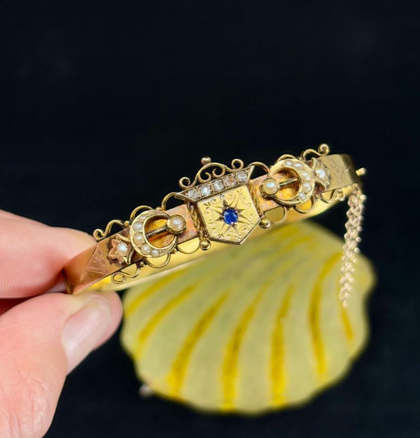 Hinged bangle with crown and crescent design by Willis and Sons, crafted in 15ct yellow gold.