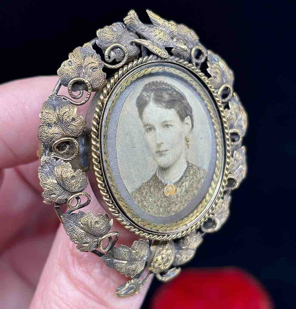Decorative revolving locket featuring a dove and vine leaves, symbolising peace and growth.