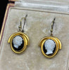 Front detail of Late Victorian black agate hardstone cameo earrings, each hand-carved with a white maiden in raised relief and framed in 15ct yellow gold.