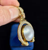 Luxury jewelry featuring a Mabé pearl surrounded by diamonds in a yellow gold setting.