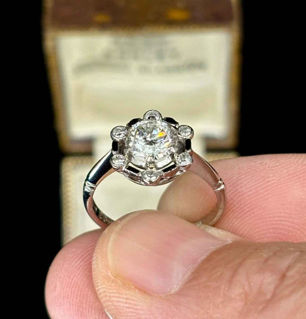 Luxury vintage diamond ring with black enamel accents and single cut diamonds.