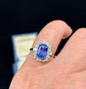 Modern design blue Ceylon sapphire ring with baguette-cut diamonds on the shoulders in white gold.