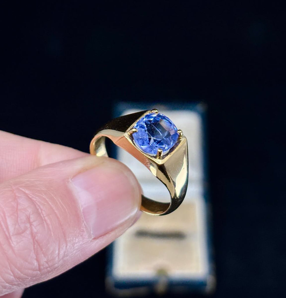 Retro men's ring design with a blue sapphire in a gold setting, 1970s style.