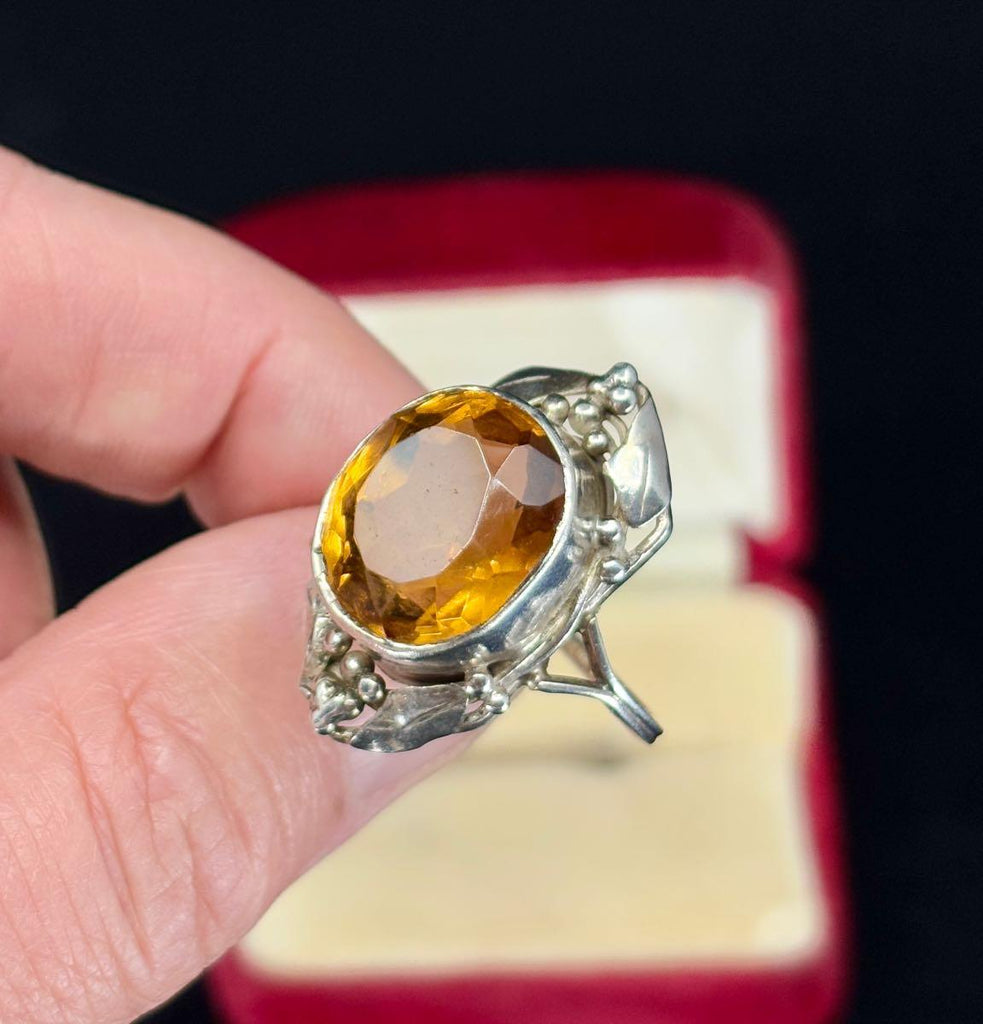 Showcasing the intricate details of the gumleaf designs in the Rhoda Wager ring that surround the oval citrine