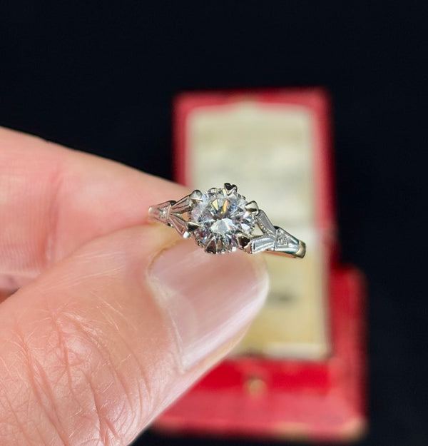 Round brilliant cut diamond engagement ring from the 1950s on a finger.