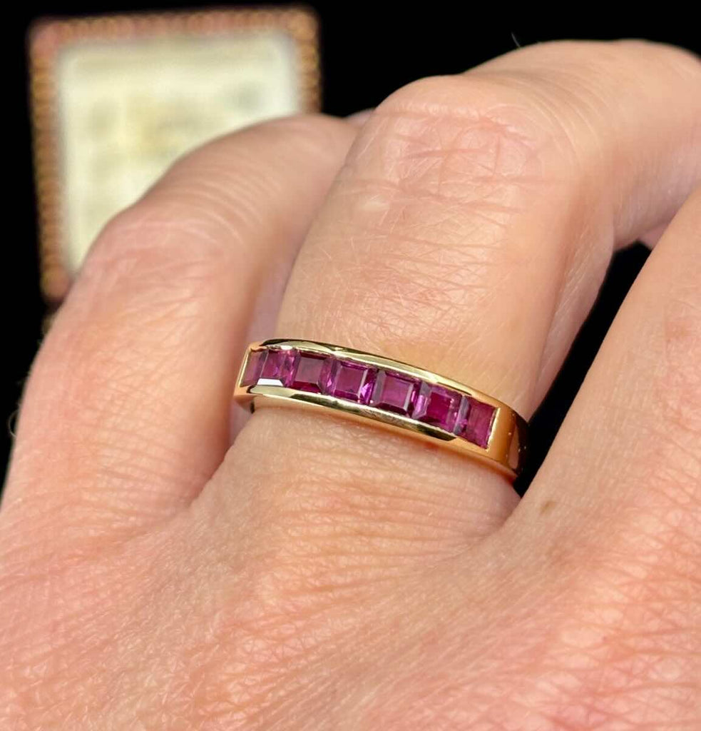 ruby eternity band in yellow gold up close on the hand