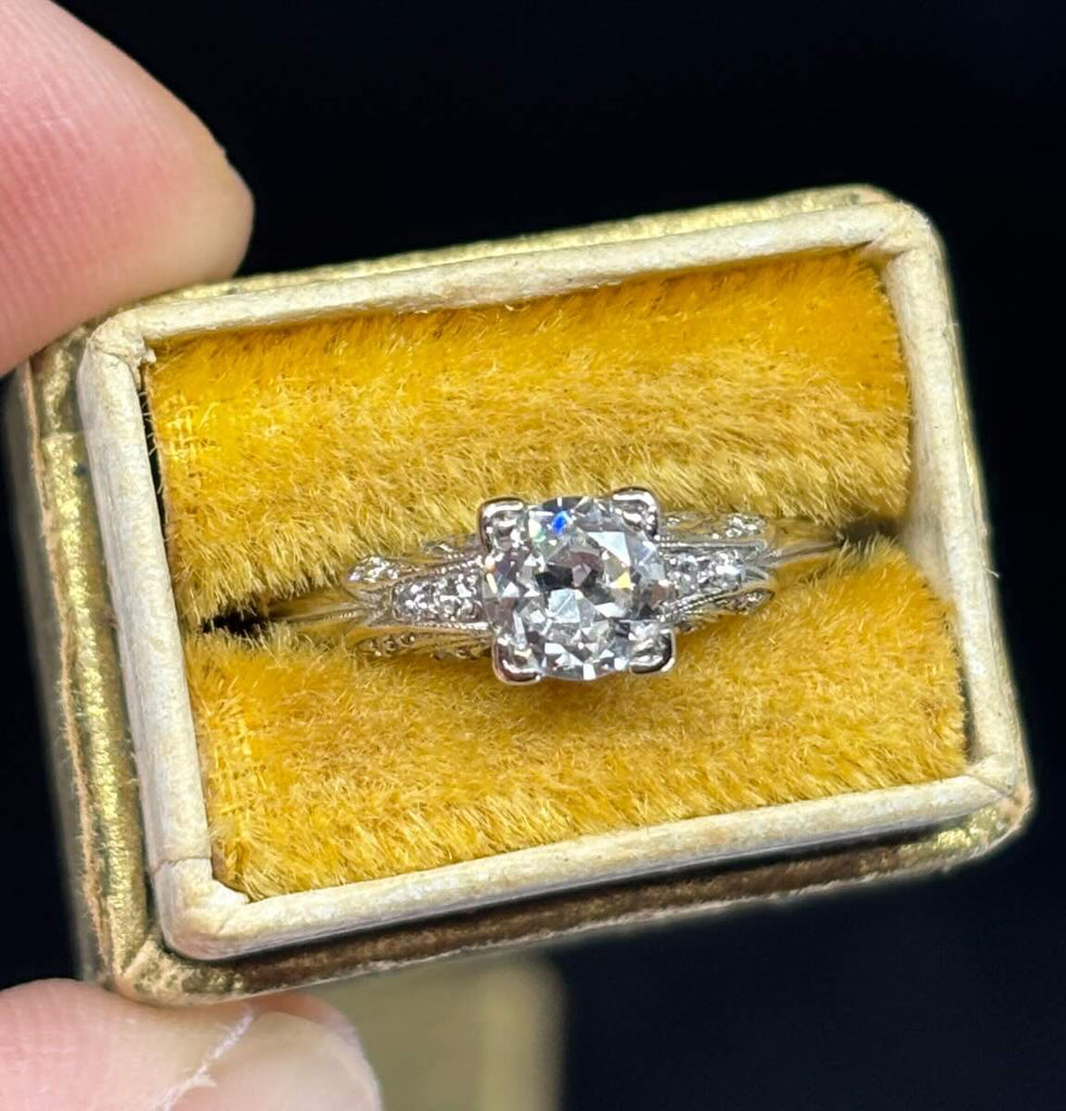 Semi‑modern cut diamond engagement ring set in platinum with four‑claw setting and delicate engraved shoulders.