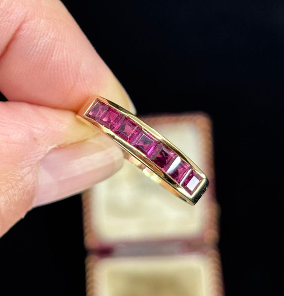 a close up of the square cut ruby eternity ring in 18ct yellow gold showing the red colour of the rubies and good clarity of the stones