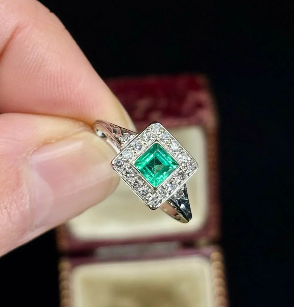 Timeless 1950s emerald and diamond ring in a luxurious platinum setting.