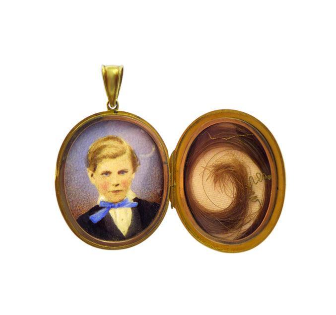 inside the Victorian 18ct Mourning Locket features a beautifully painted watercolour portrait of a young boy. On the other side of the locket is a snippet of hair, probably of the young boy pictured, in his memory.  