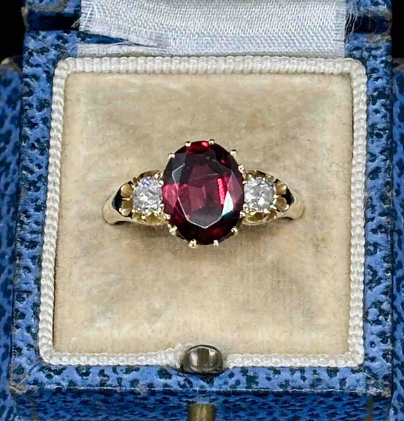 Victorian almandine garnet and diamond three stone ring in a blue antique ring box.