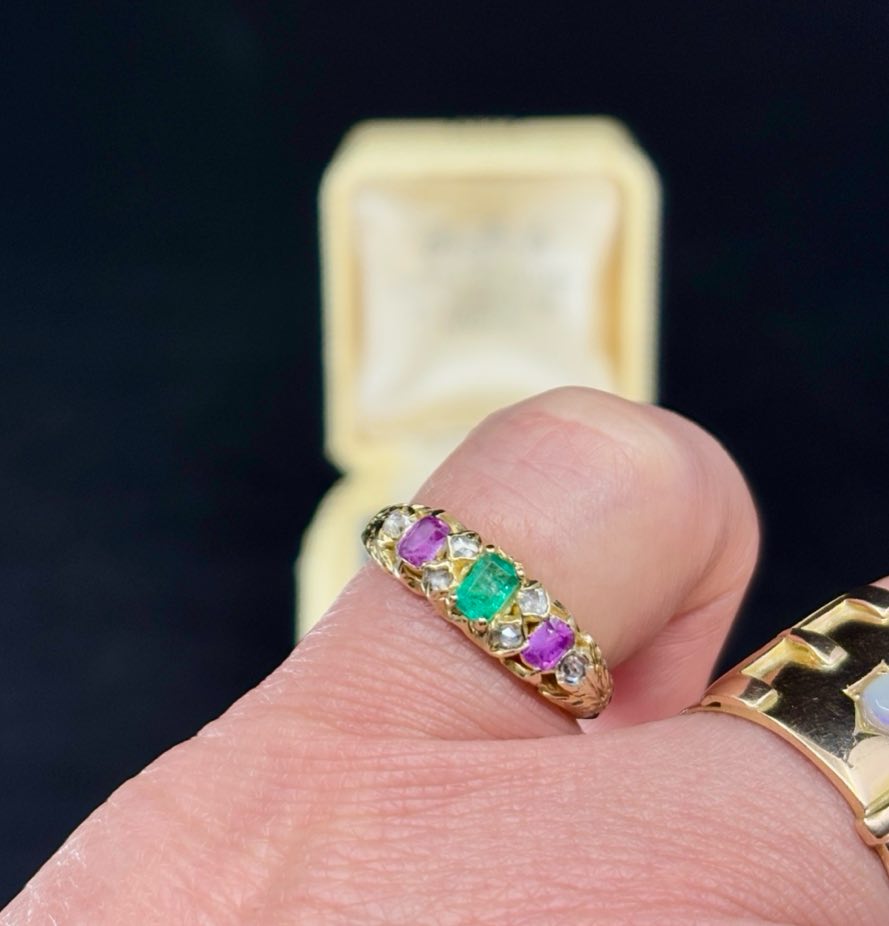 Front view of a Victorian emerald, pink sapphire, and diamond half hoop ring set in 15ct yellow gold, showcasing the emerald cut emerald centerpiece.