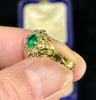 Detailed view of Victorian emerald ring with fine green gemstone and diamond cluster.