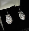 Elegant Victorian silver earrings showcasing detailed bird engravings.