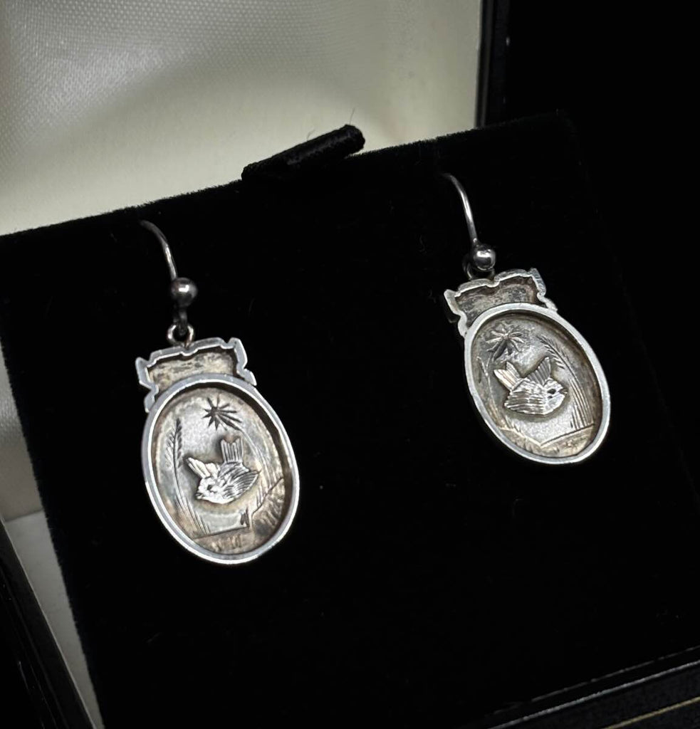 Elegant Victorian silver earrings showcasing detailed bird engravings.