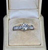 vintage 1950s diamond engagement ring highlighting six-claw setting, baguette accents and tapered white gold band. 