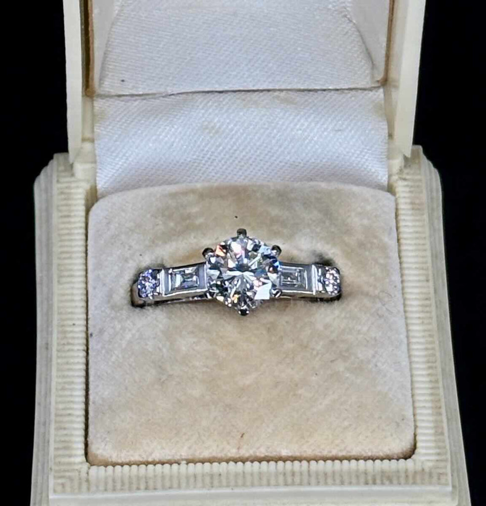 vintage 1950s diamond engagement ring highlighting six-claw setting, baguette accents and tapered white gold band. 