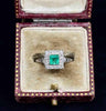 A stunning vintage 1950s emerald and diamond ring with a platinum setting.
